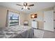 Bright bedroom features a ceiling fan, a dresser and a window view of the screened pool at 7257 Maguire Ln, Englewood, FL 34224
