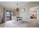Cozy dining area with modern table and chairs, view of the screened lanai, and easy access to bedroom at 7257 Maguire Ln, Englewood, FL 34224