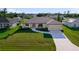 Charming home exterior features lush lawn and landscaping with a driveway leading up to the attached two car garage at 7257 Maguire Ln, Englewood, FL 34224