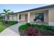 Inviting front porch of a charming single-story home with well-manicured landscaping and seating area at 7257 Maguire Ln, Englewood, FL 34224