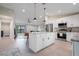 Open-concept kitchen with white cabinetry, stainless appliances, and a center island flows into the living area at 7257 Maguire Ln, Englewood, FL 34224