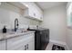 Close up of the updated laundry room with granite countertops and black stainless steel appliances at 7257 Maguire Ln, Englewood, FL 34224