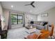 Cozy living room features plush seating, large window, ceiling fan, and neutral decor at 7257 Maguire Ln, Englewood, FL 34224