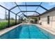Backyard pool features a screened enclosure and beautiful landscaping at 7257 Maguire Ln, Englewood, FL 34224