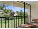 A cozy screened balcony overlooking a serene pond with lush landscaping and comfortable seating at 756 White Pine Tree Rd # 204, Venice, FL 34285