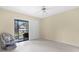 Bright bedroom features a ceiling fan, sliding glass doors, and light colored floors, offering an airy atmosphere at 756 White Pine Tree Rd # 204, Venice, FL 34285