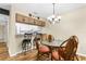 Bright dining area features a glass table, cushioned chairs, and a decorative chandelier, adjacent to the kitchen at 756 White Pine Tree Rd # 204, Venice, FL 34285