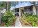 Condo exterior featuring well-maintained landscaping and mature trees, and screened in patios and balconies at 756 White Pine Tree Rd # 204, Venice, FL 34285