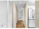 Hallway features wood-look floors, closet doors, and stainless steel refrigerator, enhancing the home's appeal at 756 White Pine Tree Rd # 204, Venice, FL 34285