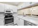 Updated kitchen with white cabinets, stainless steel appliances, and view into the dining area at 756 White Pine Tree Rd # 204, Venice, FL 34285