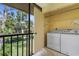 Laundry area with washer and dryer located on the screened balcony offering a tranquil view at 756 White Pine Tree Rd # 204, Venice, FL 34285