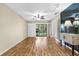 Bright living room with wood floors, fan, track lights and access to the enclosed porch at 756 White Pine Tree Rd # 204, Venice, FL 34285