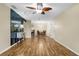 Open floor plan living room and dining area with wood floors, ceiling fan and access to the kitchen at 756 White Pine Tree Rd # 204, Venice, FL 34285