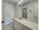 Bathroom with light patterned wallpaper, shower and white vanity with lots of counter space at 800 Capri Isles Blvd # 235, Venice, FL 34292