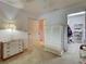Bedroom with white dressers and access to a walk-in closet with shelving at 800 Capri Isles Blvd # 235, Venice, FL 34292