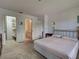 Bedroom with tan carpet, gold frame bed and entry to a bathroom and walk-in closet at 800 Capri Isles Blvd # 235, Venice, FL 34292