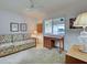 Sitting room with light carpet, ceiling fan, tropical themed couch and desk with lamps at 800 Capri Isles Blvd # 235, Venice, FL 34292