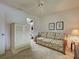 Cozy bedroom with floral sofa, white armoire, neutral walls, and ceiling fan at 800 Capri Isles Blvd # 235, Venice, FL 34292