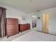 Bedroom with two wooden dressers, large windows and access to a walk-in closet at 800 Capri Isles Blvd # 235, Venice, FL 34292