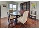 Formal dining room with dark wood table and chairs, plus built-in cabinet and floor to ceiling window at 800 Capri Isles Blvd # 235, Venice, FL 34292