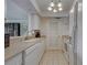 Kitchen featuring white appliances, lighting fixture and a breakfast bar with view to formal dining area at 800 Capri Isles Blvd # 235, Venice, FL 34292