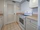 Kitchen area featuring a white electric range, white cabinets, and laminate counters at 800 Capri Isles Blvd # 235, Venice, FL 34292