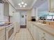 Kitchen with white cabinets, appliances, and view to living room and dining room at 800 Capri Isles Blvd # 235, Venice, FL 34292