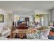 View of the open-concept living room with comfortable seating, a large TV, and access to a patio at 800 Capri Isles Blvd # 235, Venice, FL 34292