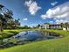 Scenic pond in the community featuring a fountain and lush green landscaping around the water at 800 Capri Isles Blvd # 235, Venice, FL 34292