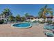 Inviting community pool surrounded by lounge chairs, umbrellas, and tropical palms, perfect for relaxation and leisure at 800 Capri Isles Blvd # 235, Venice, FL 34292
