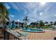 Community pool with plenty of seating and umbrellas near a beautiful lake with a fountain at 800 Capri Isles Blvd # 235, Venice, FL 34292