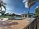 Community pool with plenty of seating and umbrellas near a beautiful lake with a fountain at 800 Capri Isles Blvd # 235, Venice, FL 34292