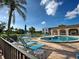 Community pool with plenty of seating and umbrellas near a beautiful lake with a fountain at 800 Capri Isles Blvd # 235, Venice, FL 34292
