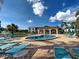 Relaxing community pool with tables, chairs, and a building with shade nearby at 800 Capri Isles Blvd # 235, Venice, FL 34292