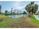 View of the tennis court in the community, surrounded by lush greenery and palm trees at 800 Capri Isles Blvd # 235, Venice, FL 34292