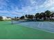 A full view of the outdoor tennis court with a blue sky at 800 Capri Isles Blvd # 235, Venice, FL 34292