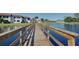 Picturesque wooden bridge leading over tranquil waters with lush landscaping and community buildings in the background at 800 Capri Isles Blvd # 235, Venice, FL 34292