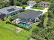 Aerial view of a home featuring a screened-in pool, green lawn, and landscaping at 9157 Genesee St, Port Charlotte, FL 33981