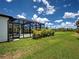 View of the backyard featuring a screened-in pool and lush green lawn at 9157 Genesee St, Port Charlotte, FL 33981