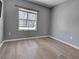 This bedroom features wood floors, neutral paint, a window with blinds and base trim at 9157 Genesee St, Port Charlotte, FL 33981