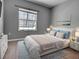 This bedroom features wood floors, neutral paint, a large window and bed with end tables at 9157 Genesee St, Port Charlotte, FL 33981