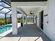 A large covered patio sits adjacent to the pool with tile flooring and a ceiling fan at 9157 Genesee St, Port Charlotte, FL 33981