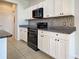 Kitchen features white cabinets, granite countertops, stainless steel appliances, and decorative tile backsplash at 9157 Genesee St, Port Charlotte, FL 33981