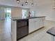 Kitchen island with granite countertop and stainless steel dishwasher, offering outdoor views to the screened pool at 9157 Genesee St, Port Charlotte, FL 33981