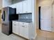 Kitchen area with stainless steel refrigerator, white cabinets, granite countertops, and decorative backsplash at 9157 Genesee St, Port Charlotte, FL 33981