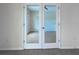 Bright living room with tiled flooring, natural light, and glass doors offering view to the next room at 9157 Genesee St, Port Charlotte, FL 33981