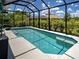 View of the pool enclosed with screen featuring clear blue water and patio area at 9157 Genesee St, Port Charlotte, FL 33981