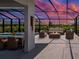 The pool patio has an outdoor dining area, seating and a fire pit at sunset at 9157 Genesee St, Port Charlotte, FL 33981