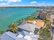 Overhead shot highlighting waterfront property with dock, bay access, and palm-lined street in a vibrant community at 931 Inlet Cir, Venice, FL 34285