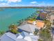 Overhead shot highlighting waterfront property with dock, bay access, and palm-lined street in a vibrant community at 931 Inlet Cir, Venice, FL 34285